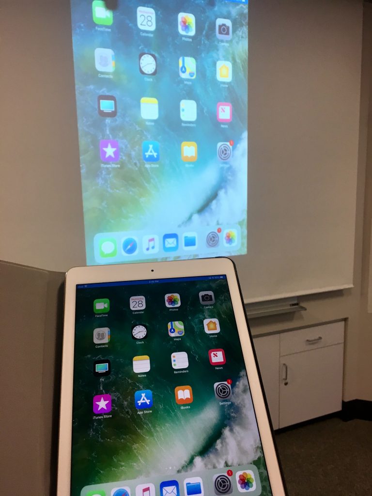 An iPad show shown sharing its screen through a projector