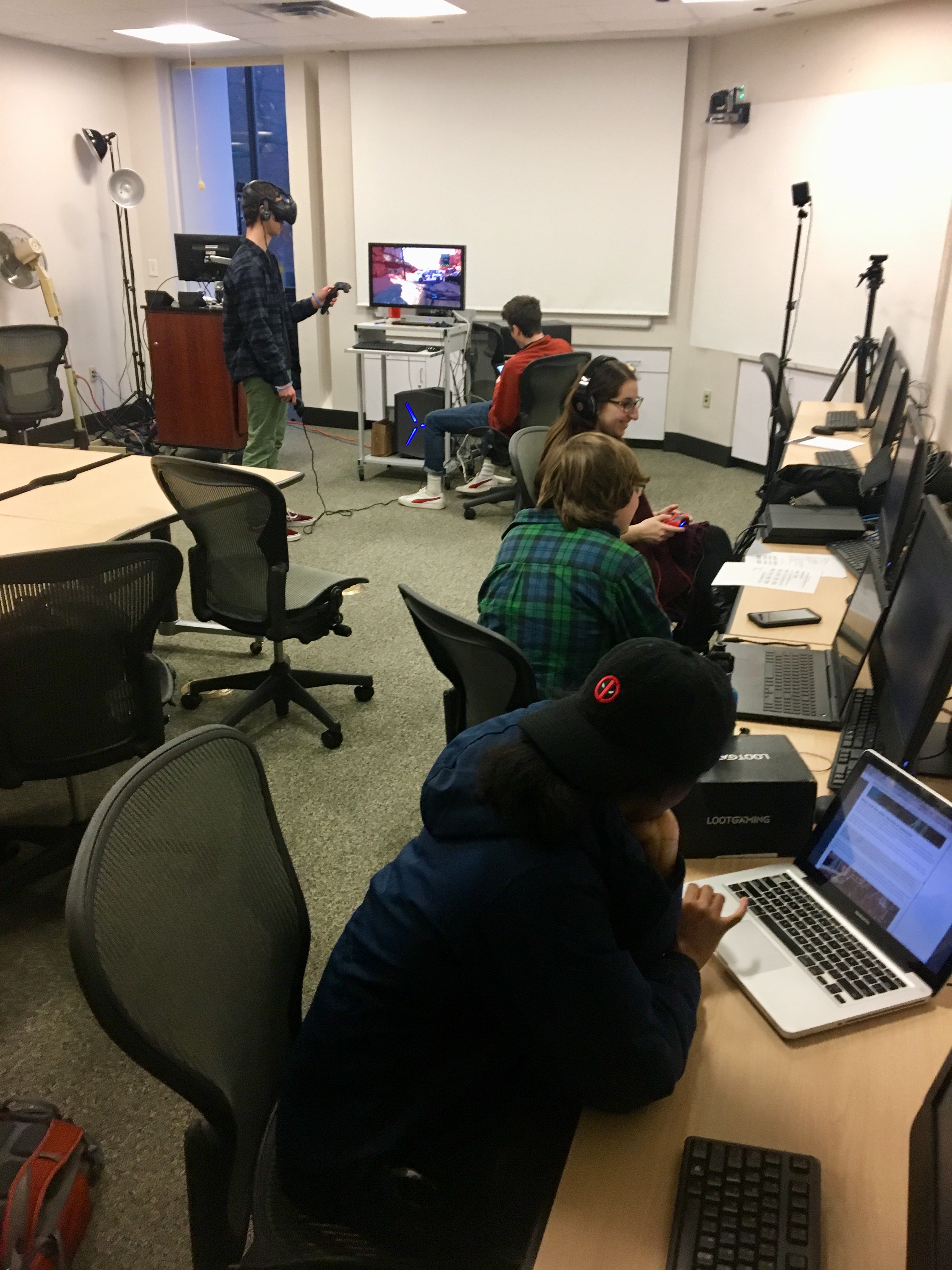 A room of students use virtual reality headsets in a classroom